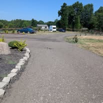 Gravel driveway loop with stone-edged planting bed