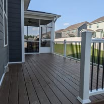 Composite deck with white railing and black balusters beside a screened porch