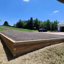 Timber-framed gravel equipment pad built beside a home